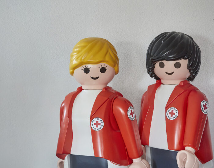 Zwei große Playmobilfiguren mit DRK-Jacke.