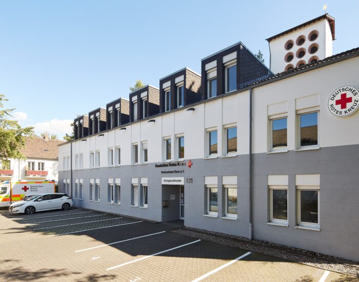 Das Gebäuder der Geschäftsstelle des Deutschen Roten Kreuzes in Bonn bei Sonnenschein.