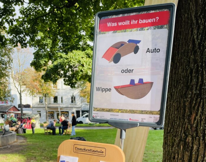 Eine Hand benutzt die Demokratiesäule.