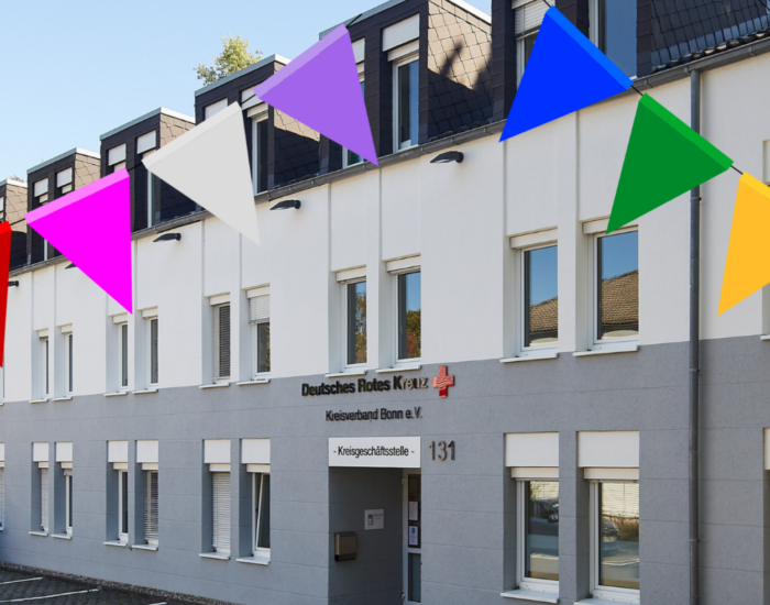 Das Gebäude der DRK-Bonn Kreisgeschäftsstelle. Eine Grafik von zwei bunten Wimpelketten ist auf dem Foto abgebildet.