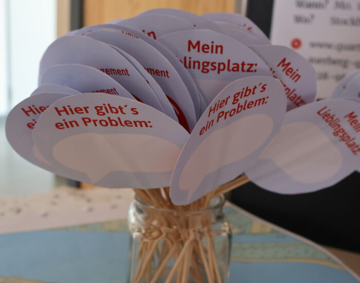 Eine Nahaufnahme von Infozetteln, die man ausfüllen kann. Auf den Zetteln kann man angeben, wo im Stadtteil man am liebsten ist und wo es noch Probleme gibt.